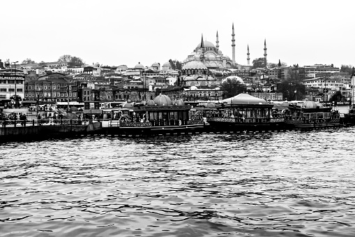 Istanbul, Turkey. - December 6, 2014: The Suleymaniye Mosque view from Golden Horn, people visit the cafe in boats and watch Bosphorus in Istanbul. Black and white image.