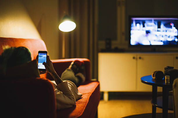 jeune femme se détendre avec smartphone sur canapé - palm leaves photos et images de collection