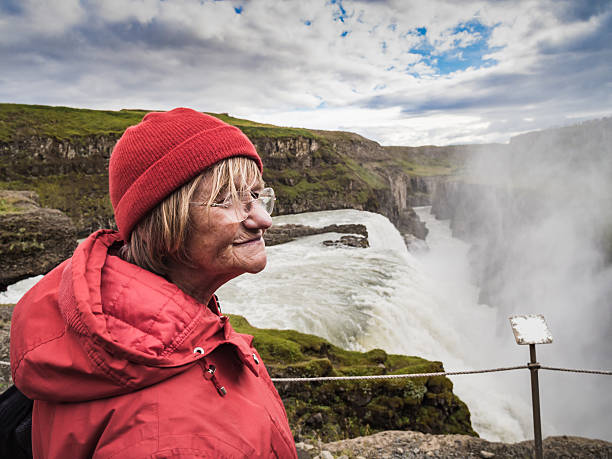 istock Senior woman is standing at a Gullfoss waterfall - Iceland 614528566