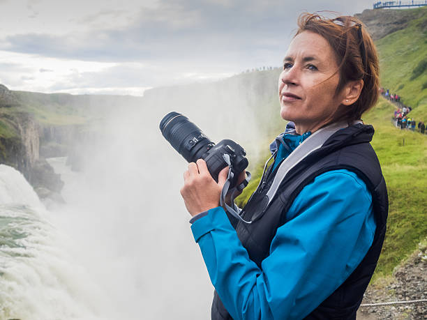 woman with a camera at  gullfoss waterfall - iceland - nature photographer imagens e fotografias de stock