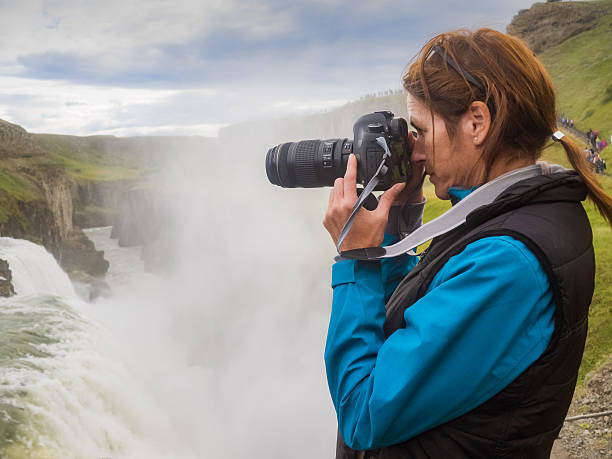 istock Woman is taking a picture at a Gullfoss waterfall 614529120