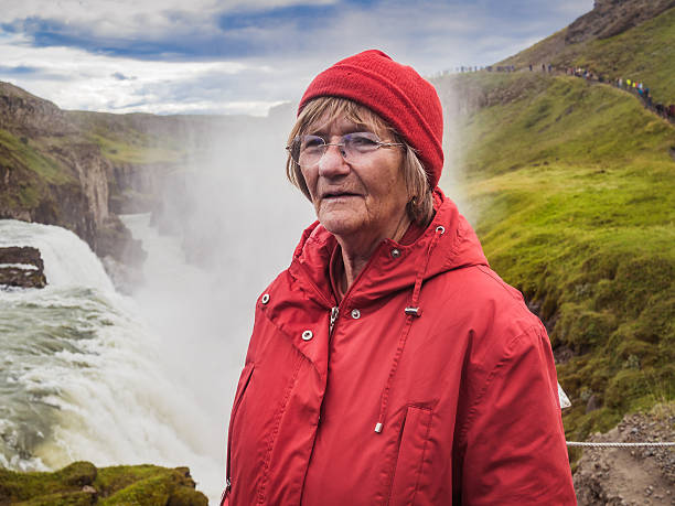 istock Senior woman is standing at a Gullfoss waterfall - Iceland 614529880