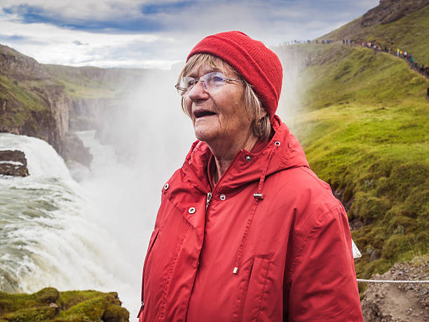 istock Senior woman is standing at a Gullfoss waterfall - Iceland 614529926