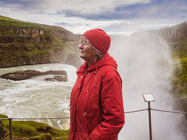 istock Senior woman is standing at a Gullfoss waterfall - Iceland 614530078