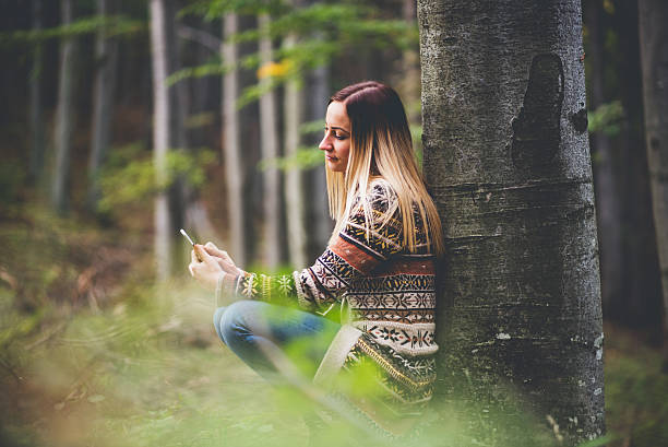 istock girl using phone in the nature 614530980
