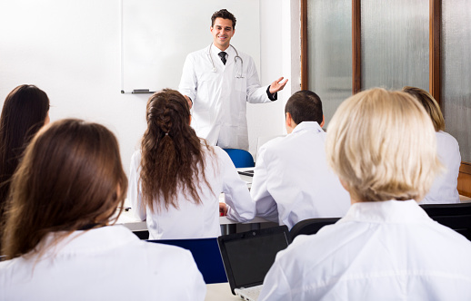 Young multinational students and attractive professor having discussion at medical faculty