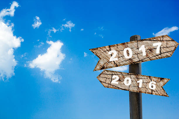 istock wood road sign new year with blue sky 614531634