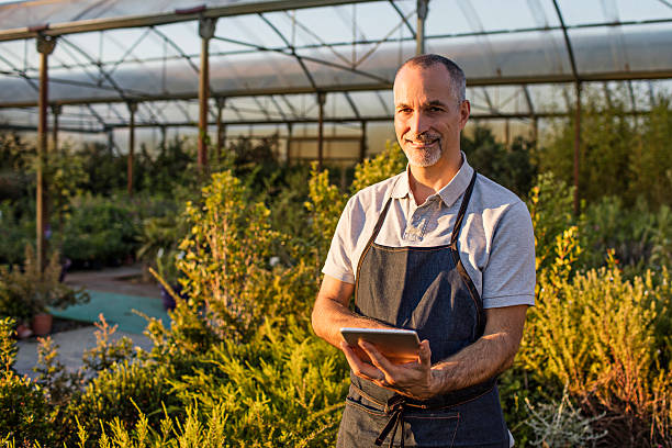 istock Mature man with digital tablet working at garden center 614533030