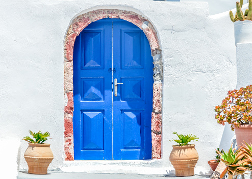 Beautiful blue door with white stone wall - Santorini, Greece