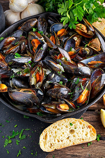 istock Boiled mussels in iron pan cooking dish. with herbs, butter 614534390