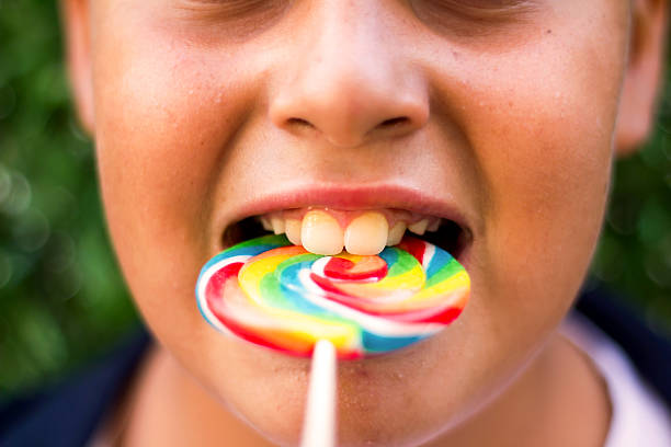 istock Boy Is Biting Lollipop With Dirty Teeth 614534424