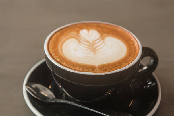 istock Latte hot coffee in a black cup with latte art 614534670