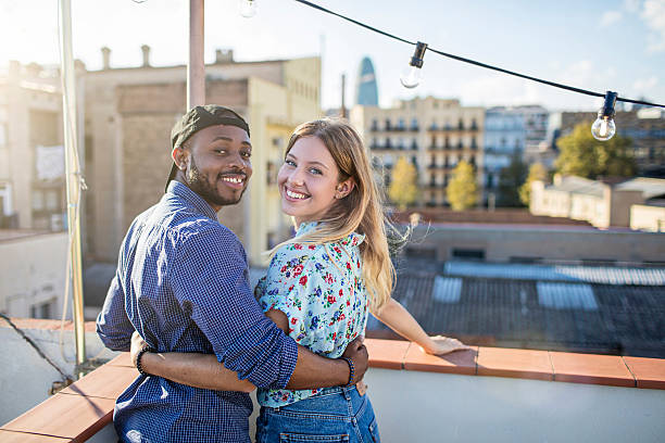 istock Happy couple standing together on a rooftop party 614534686