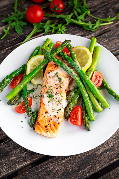 istock Fried salmon with asparagus, tomatoes, lemon, yellow lime on white 614536018