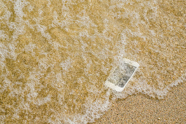 lost phone.phone fell disappear at beach - lost phone stockfoto's en -beelden