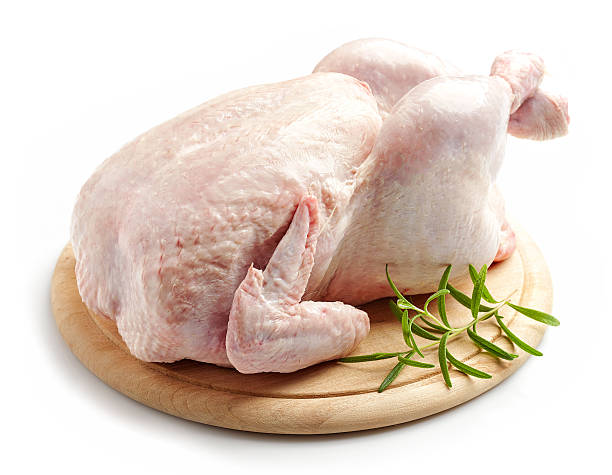 whole raw chicken whole raw chicken on wooden cutting board isolated on white background raw food stock pictures, royalty-free photos & images