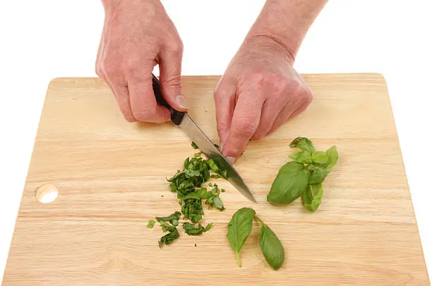 Photo of Hands chopping basil