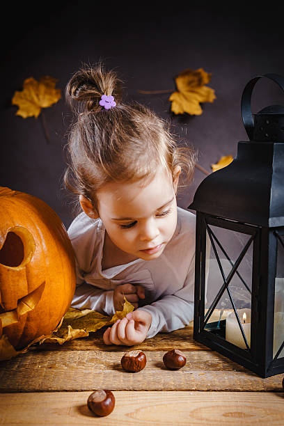 istock girl poses with a Halloween pumpkin 614609886