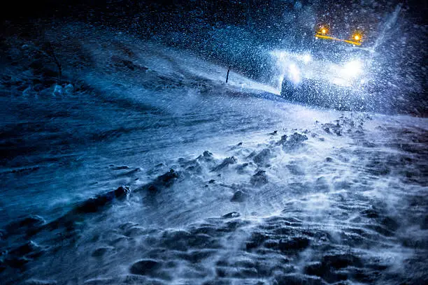 Snowplow truck cleaning the Icy Road by Night