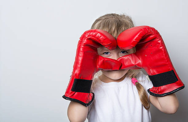 istock little girl Boxing with red gloves 614611036