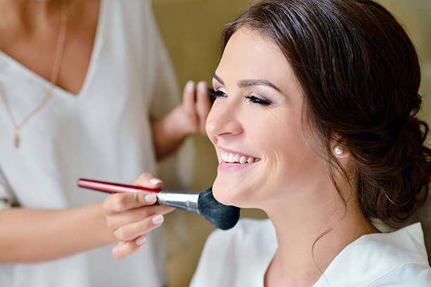 istock Wedding makeup artist making a make up for bride 614611132