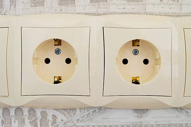 Electric sockets Detail of an electric socket block with two connection points. Interlocked electrical outlet on the wall. Faceplate stock pictures, royalty-free photos & images