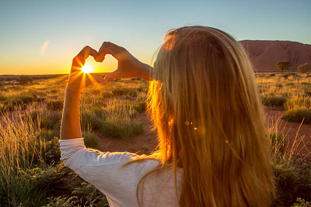 istock View of female framing sunset into heart shape 614611994