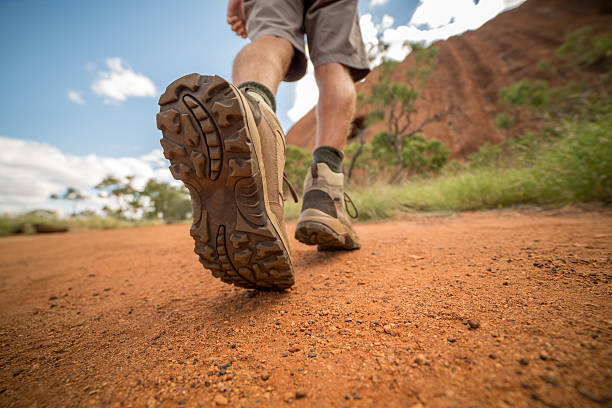 istock Low angle view of hiker's boots walking on dirt road 614614620