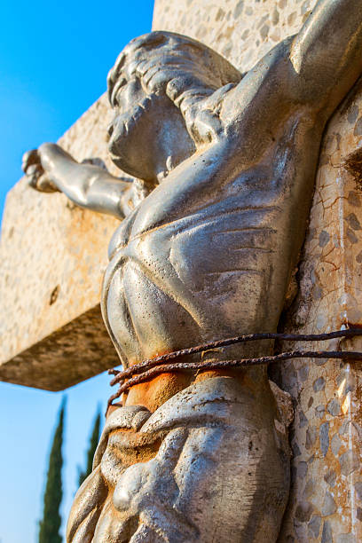 istock Jesus tied to a cross in graveyard 614615908