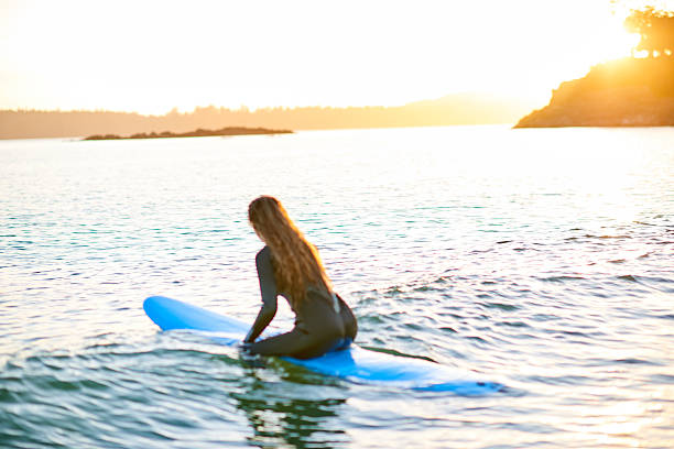 istock Strong beautiful young woman with surf on the beach 614619032