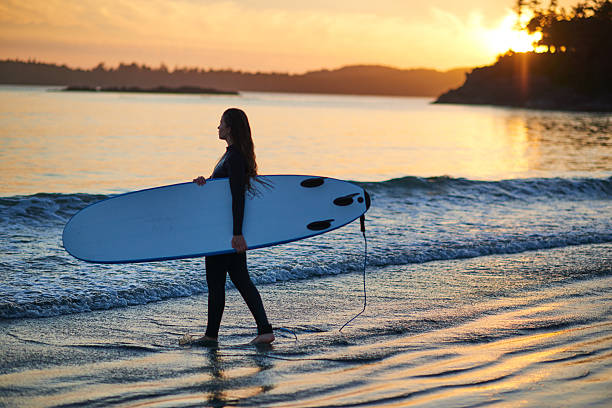 istock Strong beautiful young woman with surf on the beach 614619764
