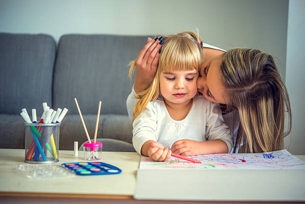 istock Mother and daughter painting 614619838
