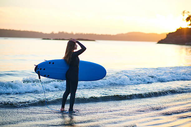 istock Strong beautiful young woman with surf on the beach 614620060