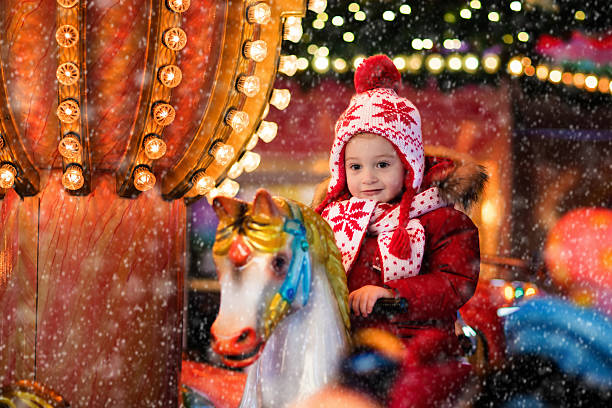 istock Little boy riding carousel on Christmas market 614622506