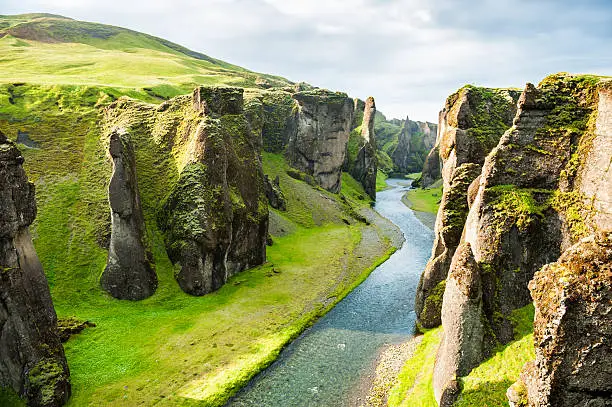 Photo of Fjadrargljufur canyon with river and big rocks.