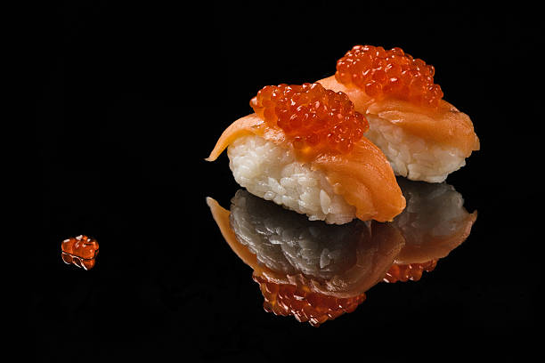 istock Sushi and red caviar on black acryle 614629914