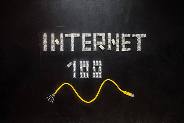 Word "Internet" and numeral "100", made of connectors RJ45 Word "Internet" and numeral "100", made of connectors RJ45 and yellow patch cord isolated over the black scratched board background. computer plan fiber optic engineer stock pictures, royalty-free photos & images