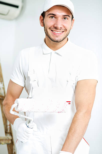 istock Young man painting walls. 614636502