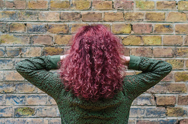 istock Young woman with her back looking at a blank brick 614637524