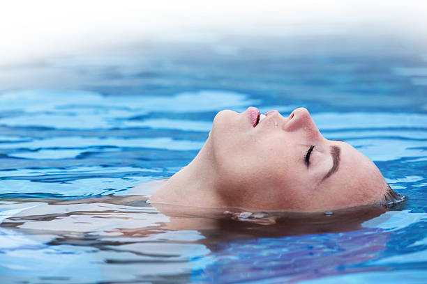 istock Woman floating in pool 614639130