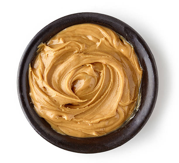 istock Peanut butter in round dish isolated on white background 614640672