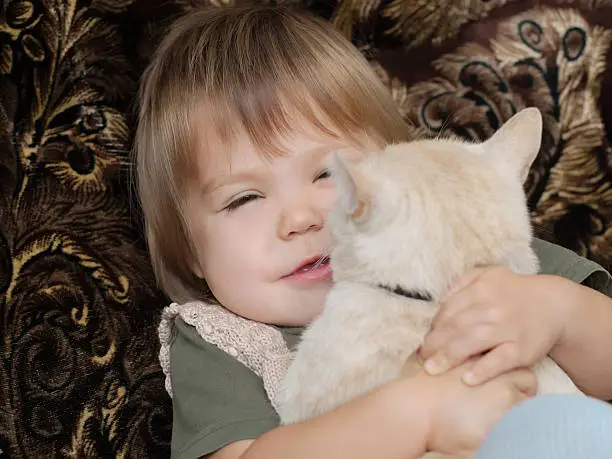 Photo of Child hugging cat