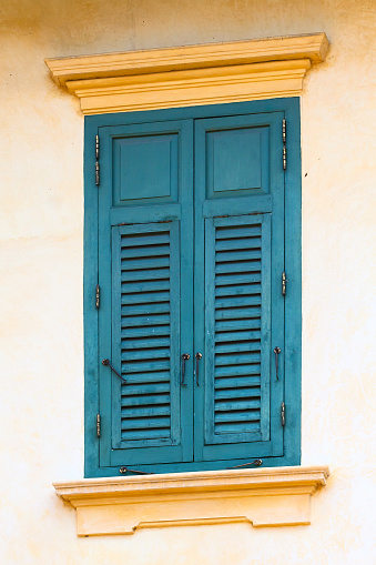 vintage window wood blue color and decorative shutters. Stukturnoy on the wall with decorative elements from gypsum.