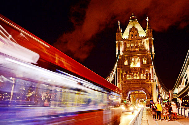 istock Motion blurred red bus with blue lights on Tower Bridge 614643860