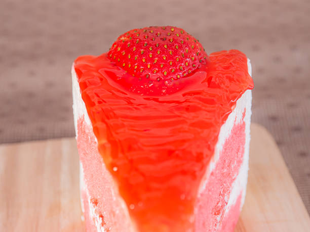 cake cut into equal pieces with strawberries, top view on a black background