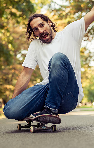 istock Skateboarder squatting on a skateboard and ride through the forest 614644818
