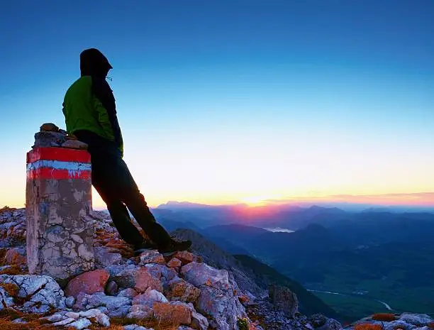 Photo of Tired hiker sit on mountain peak. Austria Germany Alps