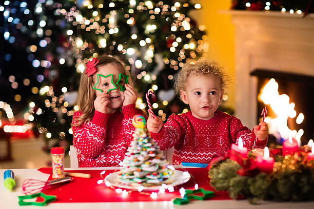 istock Kids baking gingerbread house on Christmas eve 614650642