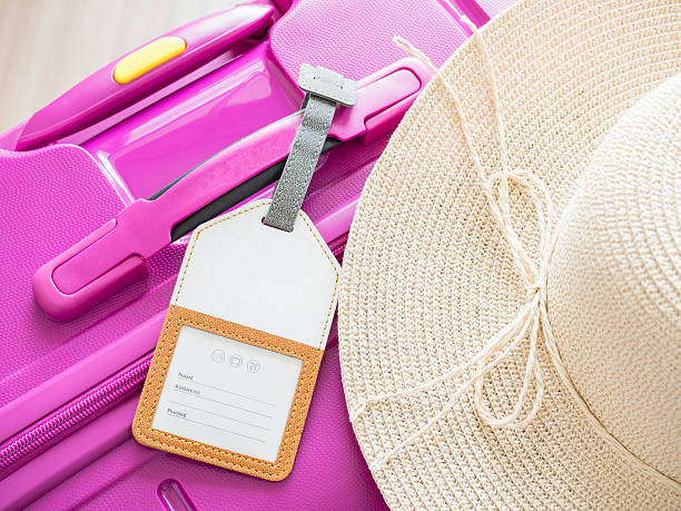 istock luggage tag and white hat on pink suitcase 1 614651386