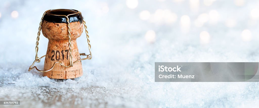 New Year 2017 with a champagne cork New Year background 2017 with a champagne cork in the snow and bokeh Ice Stock Photo